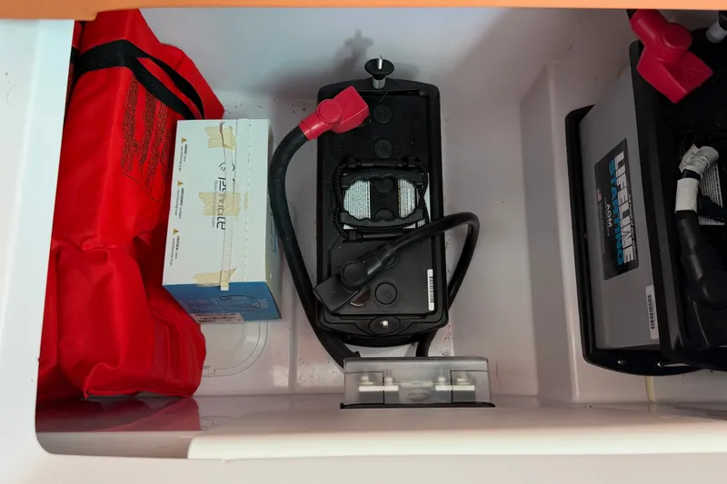 Slide: The Image of Storage compartment in a 2023 Axopar 28 Cabin with battery and safety equipment. - 22