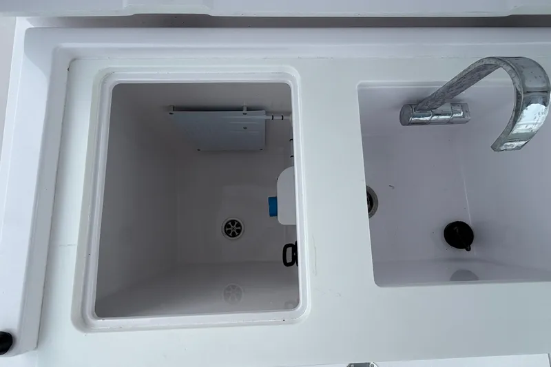 Slide: The Image of 2023 Axopar 28 Cabin sink and storage compartment detail. - 42