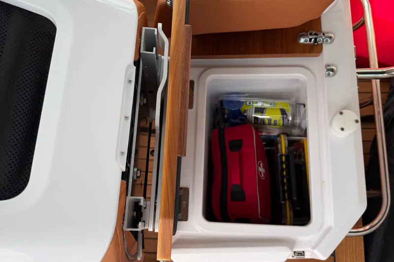 Slide: The Image of Storage compartment in 2023 Axopar 28 Cabin boat with emergency kit and supplies. - 20