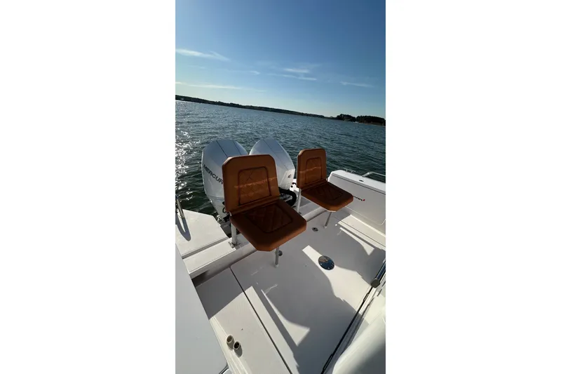 Slide: The Image of 2023 Axopar 28 Cabin boat with twin Mercury engines on a sunny day. - 48