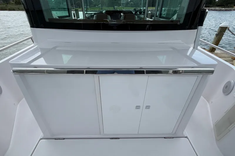 Slide: The Image of 2023 Axopar 28 Cabin boat interior with sleek white cabinetry and chrome accents. - 40