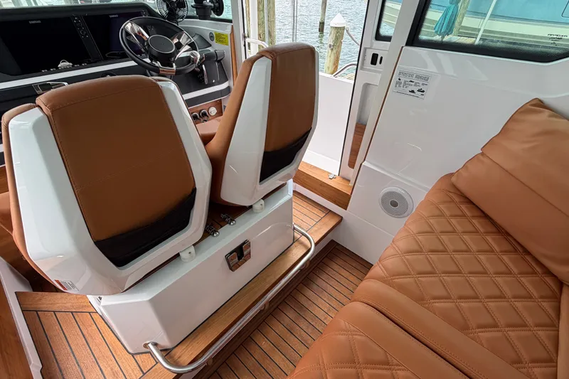 Slide: The Image of Interior of 2023 Axopar 28 Cabin with brown leather seats and wood flooring. - 17