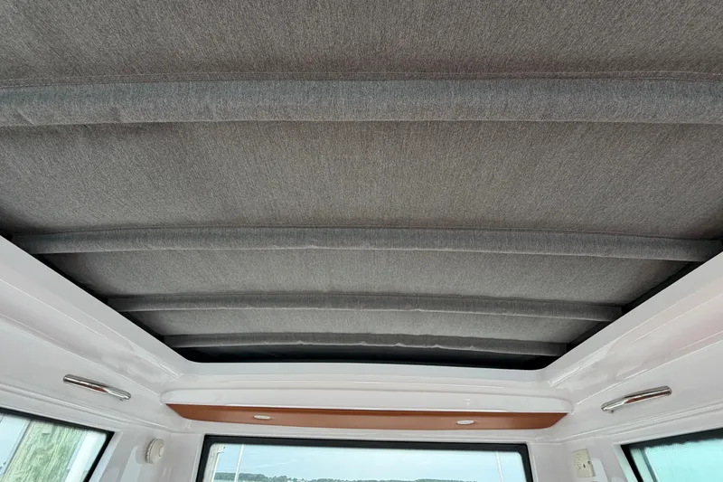 Slide: The Image of 2023 Axopar 28 Cabin interior roof with sleek, modern design and fabric finish. - 24