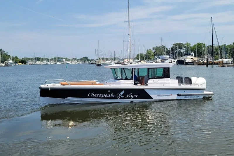 The Image of 2023 Axopar 28 Cabin boat on calm water, labeled "Chesapeake Flyer." - 1