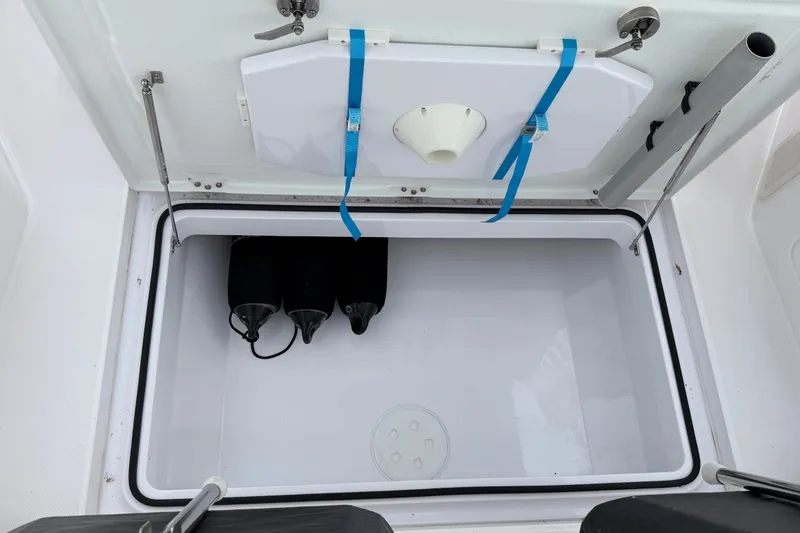 Slide: The Image of Storage compartment of 2023 Axopar 28 Cabin boat, featuring secure straps and fenders. - 46