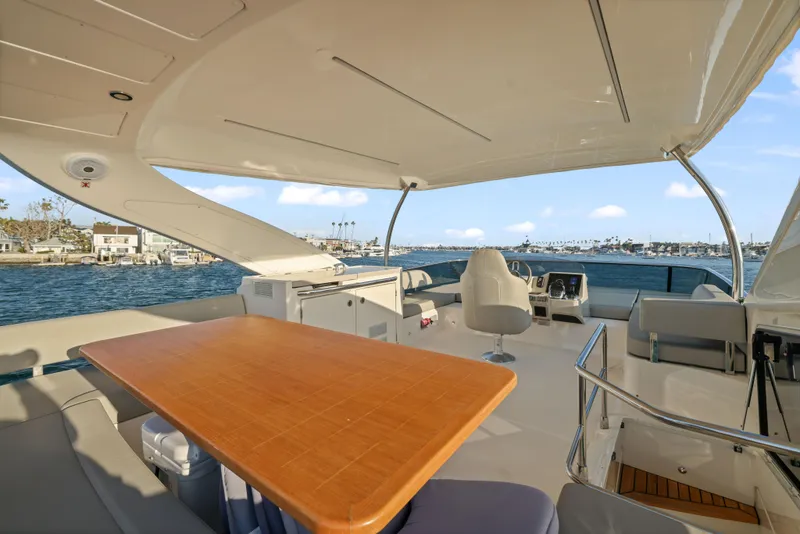 Slide: The Image of Die Absolute Navetta 48 von 2020 zeigt ein elegantes Deck mit einem Holztisch und bequemen Sitzgelegenheiten. - 13