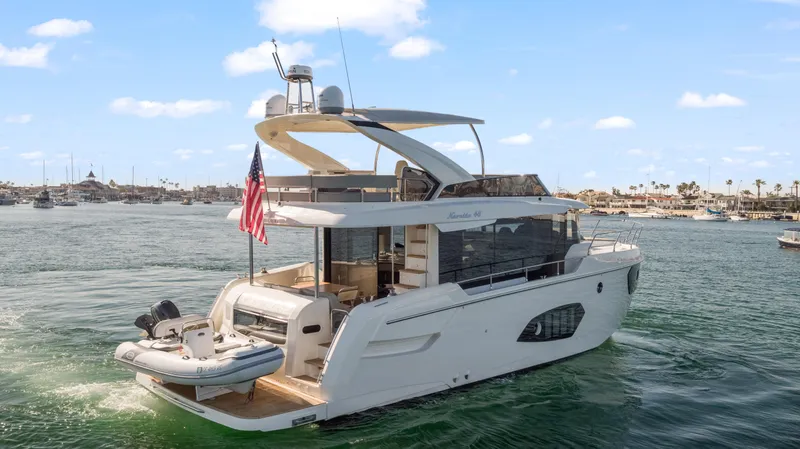 Slide: The Image of Die Absolute Navetta 48 von 2020 fährt auf ruhigem Wasser. Sie hat ein elegantes Design und eine amerikanische Flagge. - 4