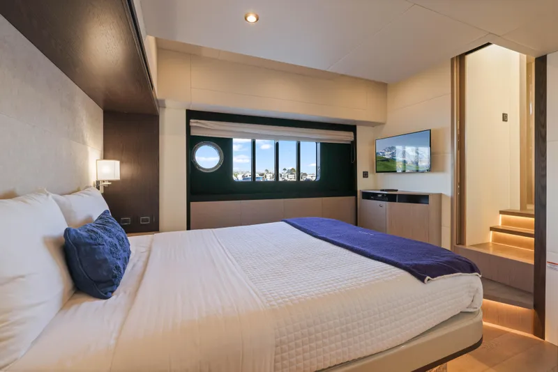 Slide: The Image of Das Bild zeigt eine luxuriöse Kabine mit einem großen Bett, einem Fenster und einem Fernseher. - 31