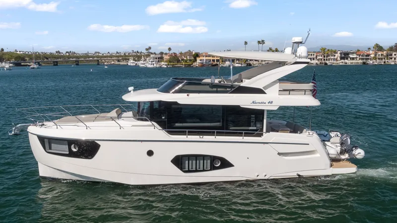 Slide: The Image of Die Absolute Navetta 48 von 2020 fährt auf ruhigem Wasser. Sie hat ein modernes Design und große Fenster. - 2
