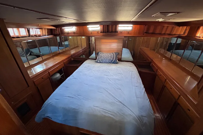 Slide: The Image of Luxurious 1991 Kha Shing Motoryacht bedroom with wood paneling and mirrored cabinets. - 43