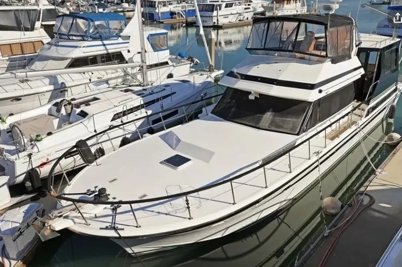 The Image of 1991 Kha Shing Motoryacht docked in a marina, surrounded by other boats. - 1