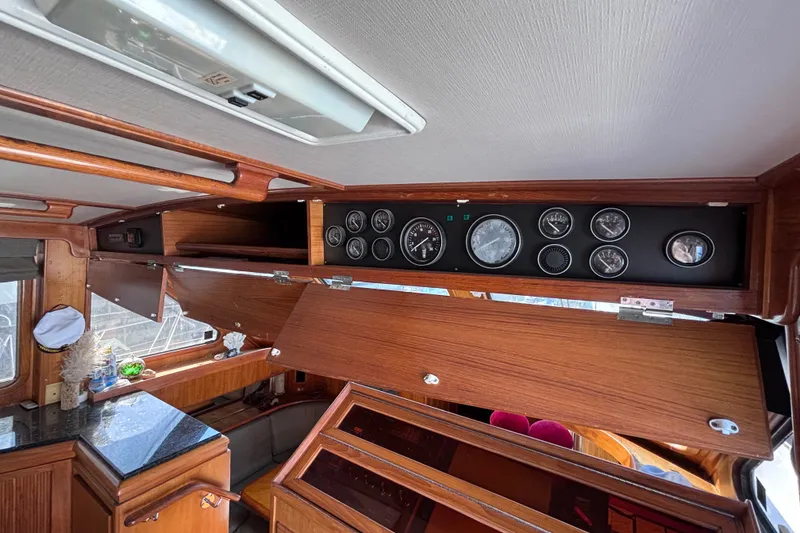 Slide: The Image of Interior view of a 1991 Kha Shing Motoryacht dashboard with wooden paneling and gauges. - 56