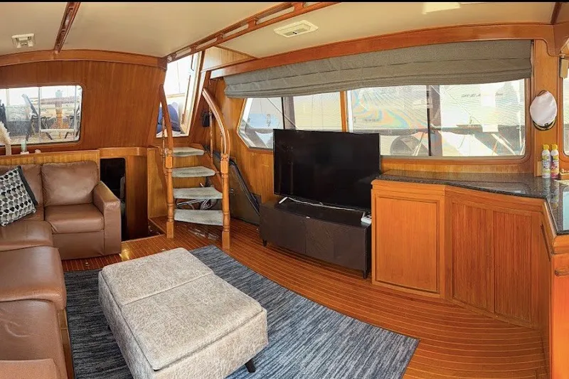 Slide: The Image of Luxurious 1991 Kha Shing Motoryacht interior with leather seating, TV, and wooden accents. - 59