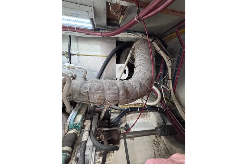 Slide: The Image of Engine room of a 1991 Kha Shing Motoryacht, featuring various pipes and cables. - 35