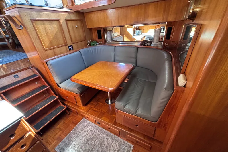 Slide: The Image of Luxurious 1991 Kha Shing Motoryacht interior with wooden dining area and cushioned seating. - 22