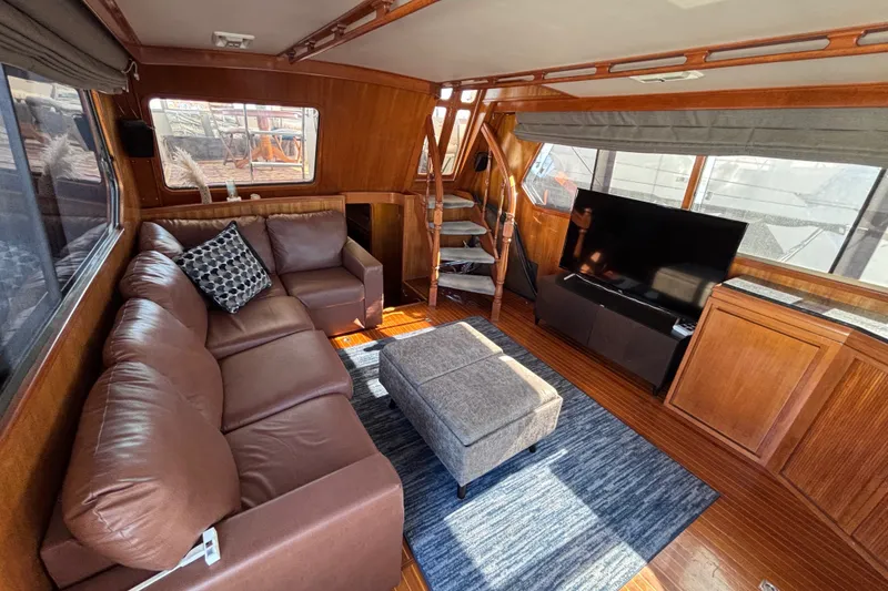 Slide: The Image of Luxurious 1991 Kha Shing Motoryacht interior with leather sofa, TV, and wooden accents. - 18