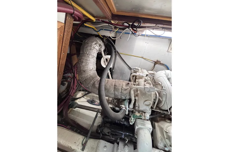 Slide: The Image of Engine room of a 1991 Kha Shing Motoryacht, showcasing complex piping and machinery. - 36