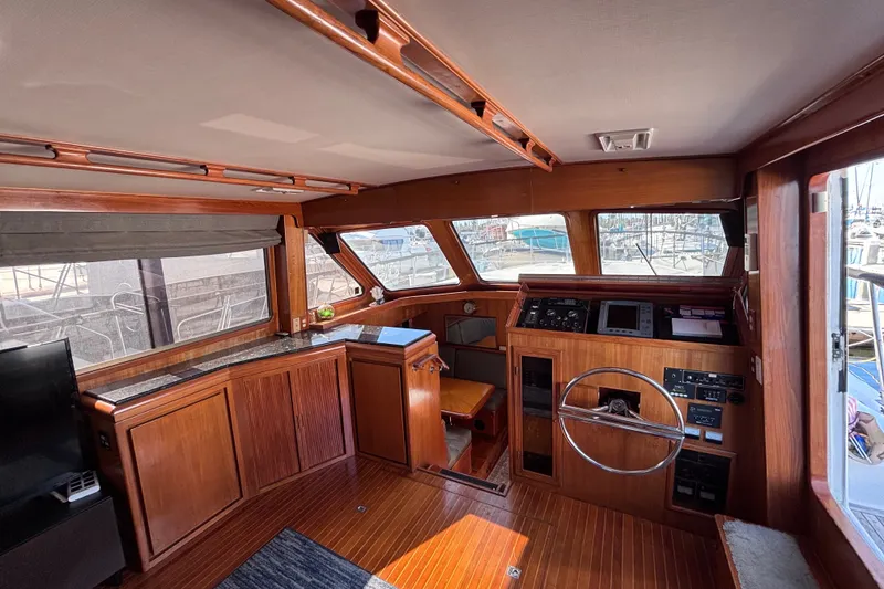 Slide: The Image of Interior of a 1991 Kha Shing Motoryacht with wooden finishes and navigation equipment. - 19