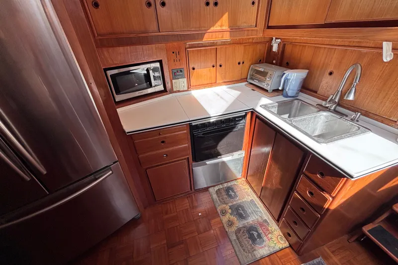 Slide: The Image of Kitchen area of a 1991 Kha Shing Motoryacht with wooden cabinets and modern appliances. - 23
