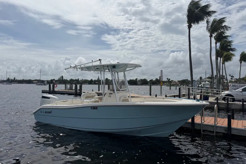 The Image of 2021 Bulls Bay 230 Center Console boat docked by palm trees under cloudy sky. - 18