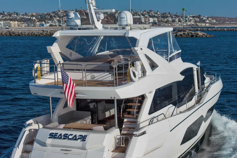 Slide: The Image of 2018 Sunseeker 76 Yacht cruising on the ocean with cityscape in the background. - 8