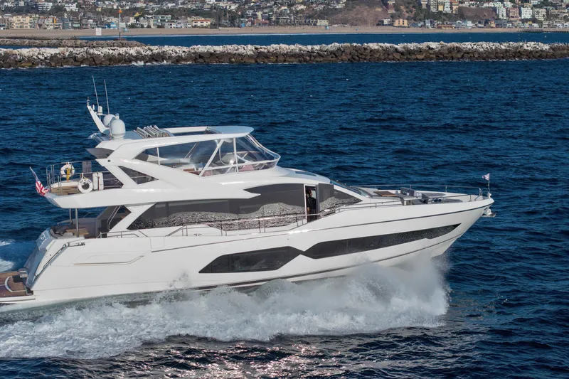 Slide: The Image of 2018 Sunseeker 76 Yacht cruising on the ocean near a coastal city. - 5