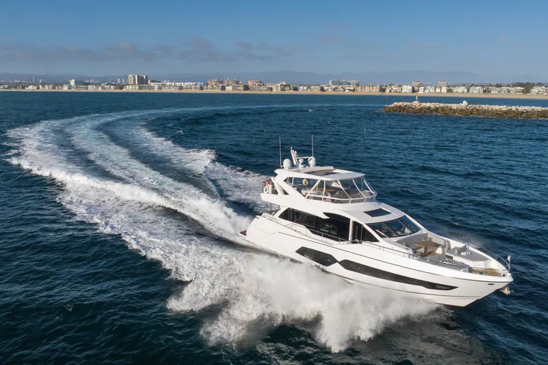 Slide: The Image of 2018 Sunseeker 76 Yacht cruising on open water near a coastal city. - 3