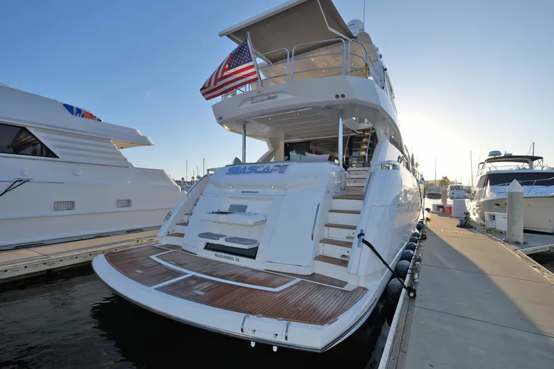 Slide: The Image of 2018 Sunseeker 76 Yacht docked, featuring elegant design and American flag. - 79