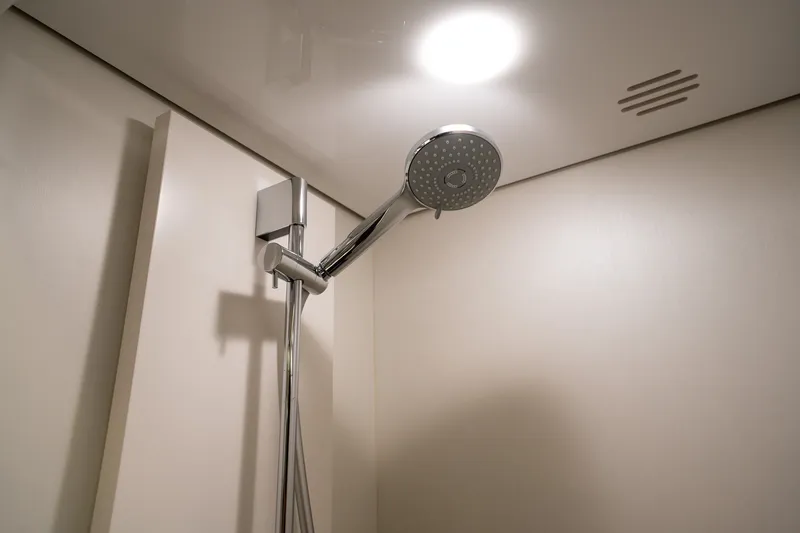Slide: The Image of Modern showerhead in 2023 Azimut S8 yacht bathroom, featuring sleek design and lighting. - 23
