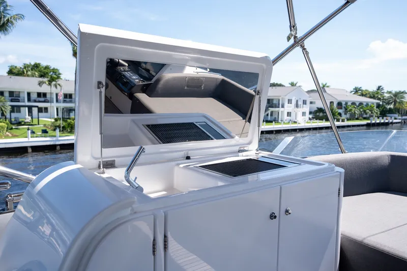 Slide: The Image of 2023 Azimut S8 yacht with outdoor kitchenette, featuring grill and storage, docked by waterfront homes. - 65