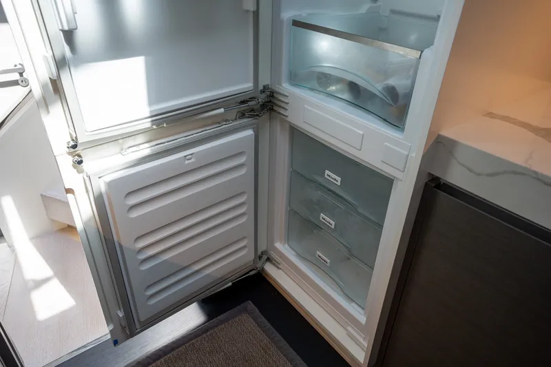 Slide: The Image of Open refrigerator in 2023 Azimut S8 yacht, showcasing organized storage compartments. - 39