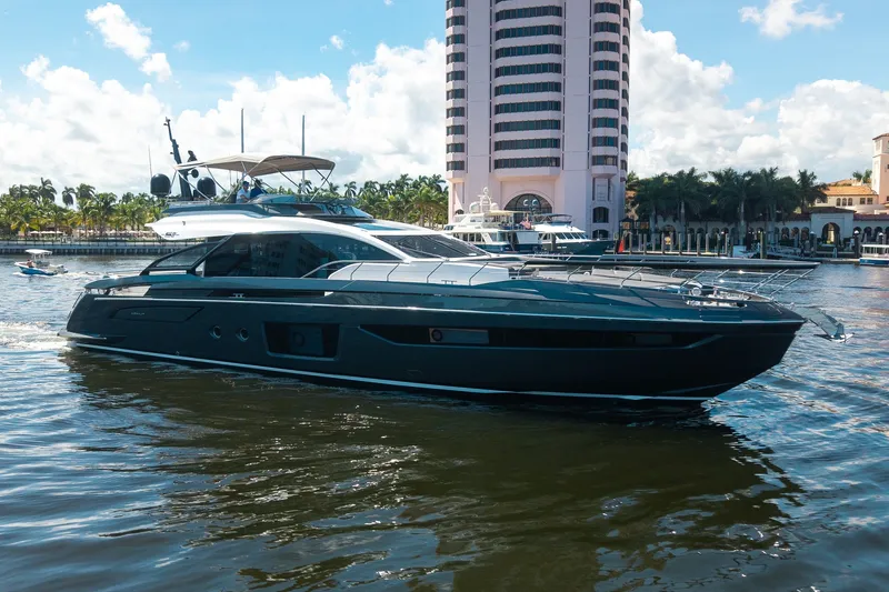 The Image of 2023 Azimut S8 yacht cruising near a waterfront cityscape with palm trees and buildings. - 1