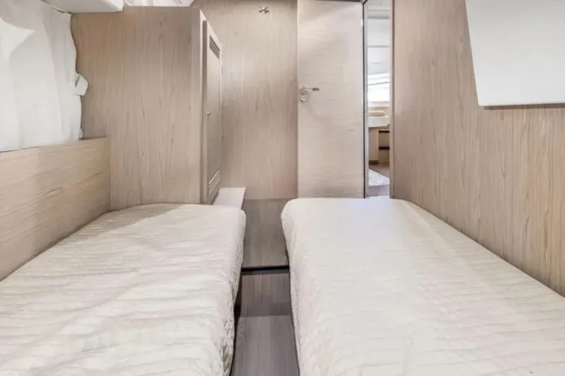 Slide: The Image of 2024 Beneteau Swift Trawler 41 Fly cabin with twin beds and modern wood finish. - 43
