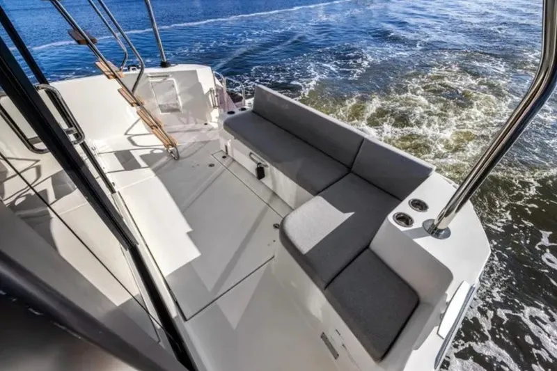 Slide: The Image of 2024 Beneteau Swift Trawler 41 Fly deck with seating, overlooking ocean waves. - 10