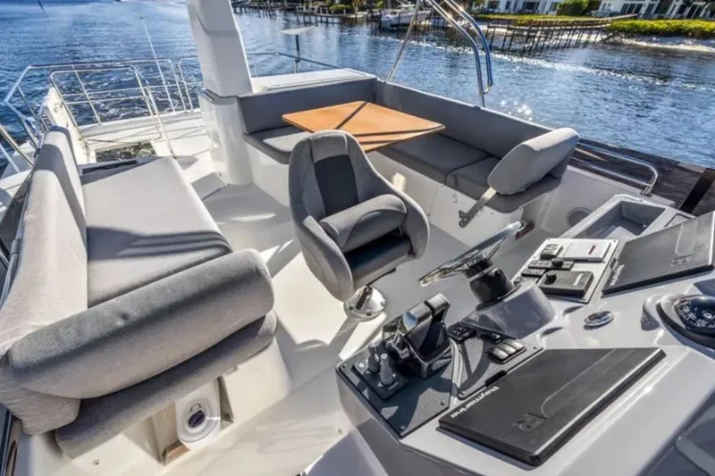 Slide: The Image of 2024 Beneteau Swift Trawler 41 Flybridge with modern helm and seating area on water. - 22