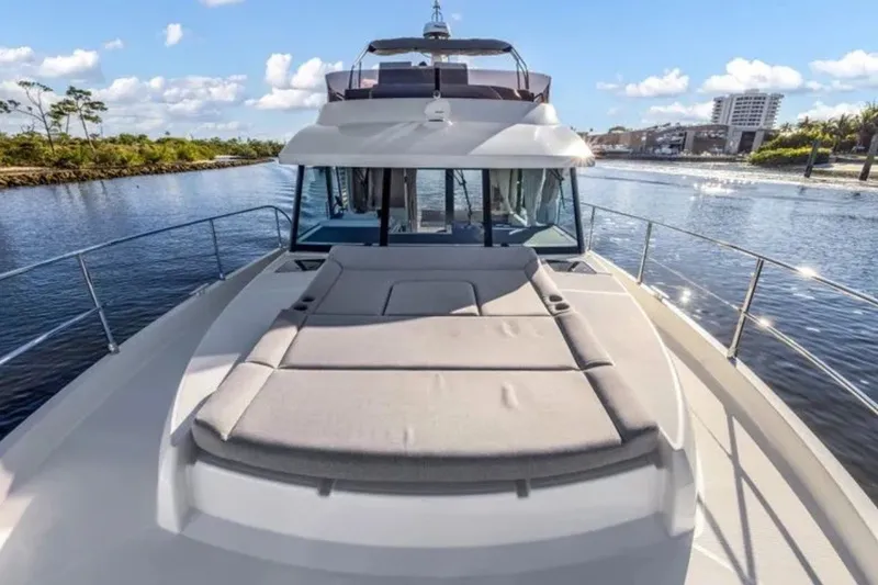 Slide: The Image of 2024 Beneteau Swift Trawler 41 Fly on serene waterway, showcasing spacious deck and sleek design. - 13