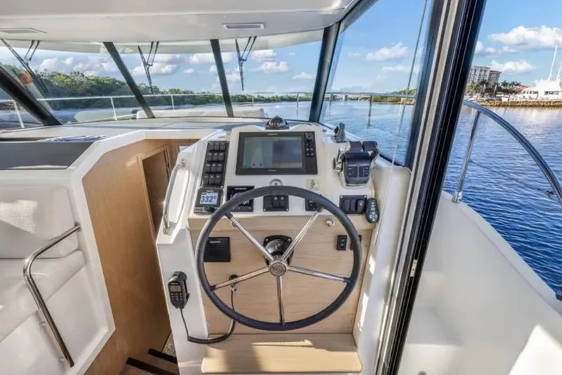 Slide: The Image of 2024 Beneteau Swift Trawler 41 Fly helm with modern navigation equipment and scenic water view. - 30