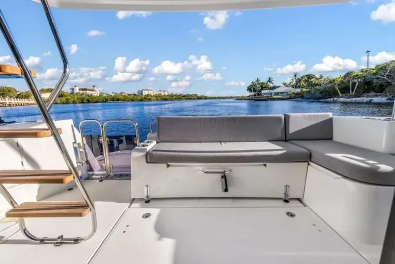 Slide: The Image of 2024 Beneteau Swift Trawler 41 Fly deck with seating, overlooking serene waterway. - 9