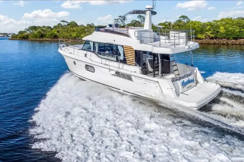 Slide: The Image of 2024 Beneteau Swift Trawler 41 Fly cruising on a serene waterway. - 2