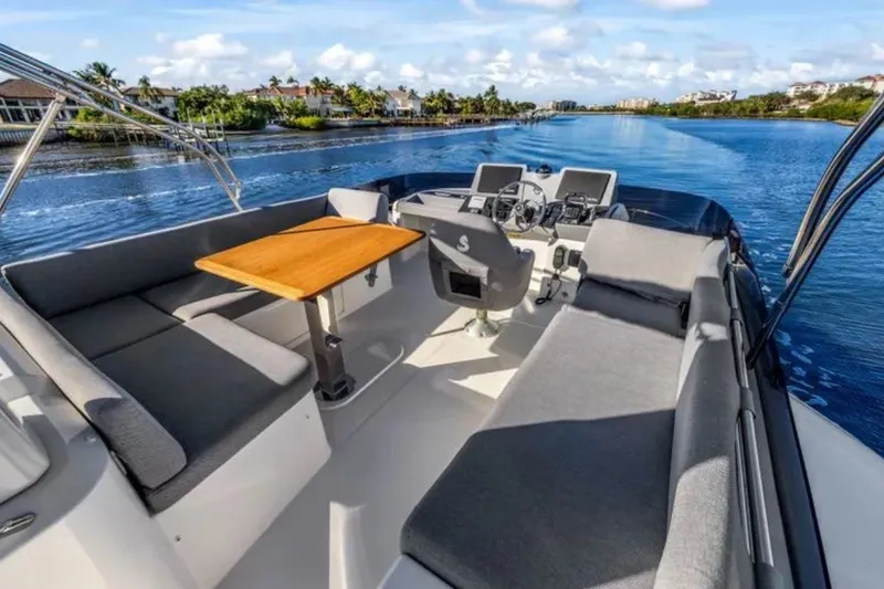 Slide: The Image of 2024 Beneteau Swift Trawler 41 Fly, spacious deck with seating, cruising on a serene waterway. - 20