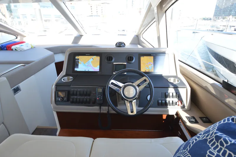 Slide: The Image of The cockpit of the 2018 Sea Ray 460 Express Cruiser features a modern helm with dual screens. - 33
