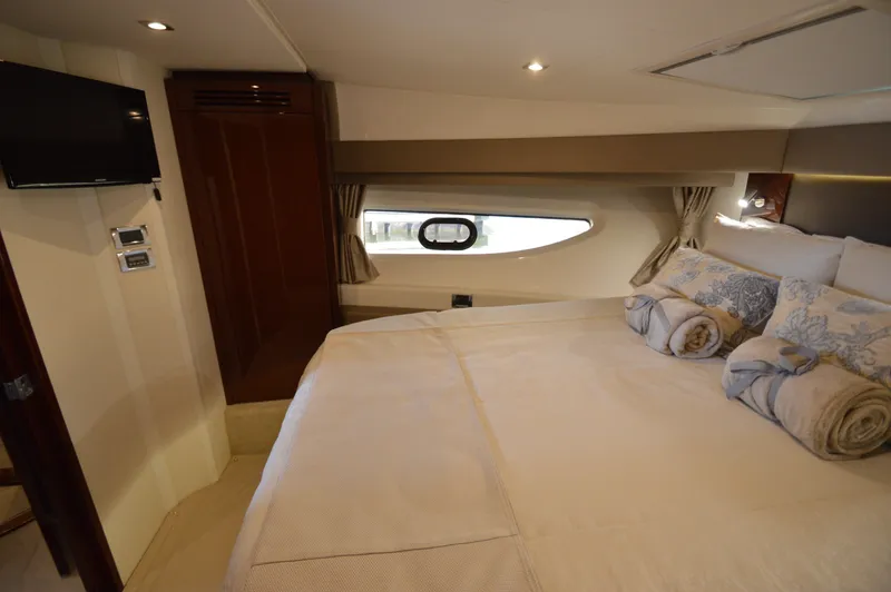 Slide: The Image of Luxurious cabin with a large bed, window, and TV in a Sea Ray 460 Express Cruiser. - 47
