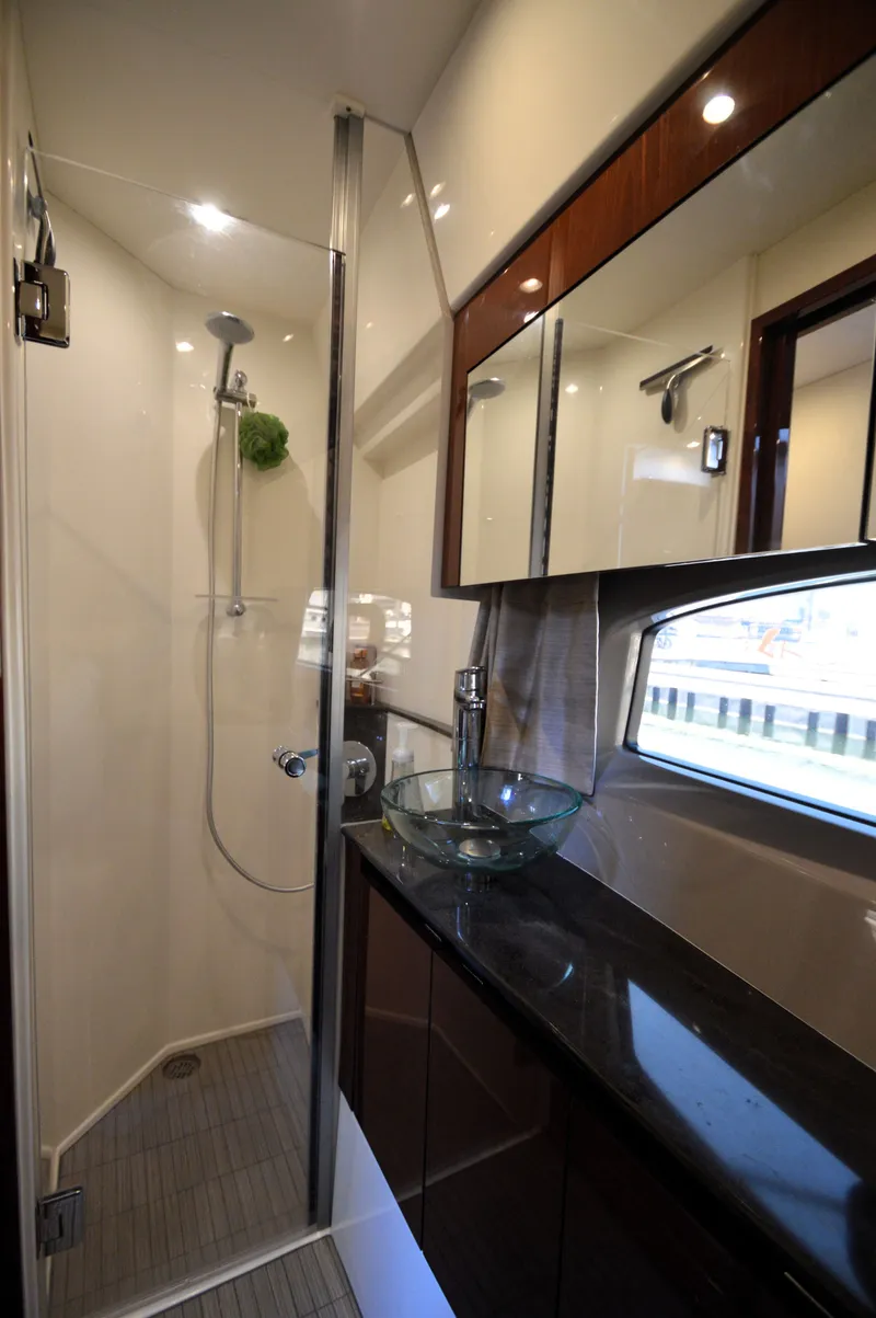 Slide: The Image of The image shows a modern boat bathroom with a glass shower and sleek sink. - 42