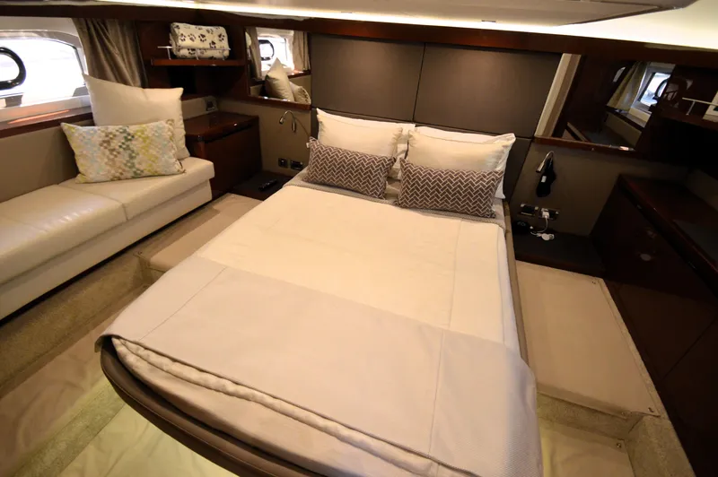 Slide: The Image of Luxurious cabin featuring a large bed, pillows, and a sofa, surrounded by elegant wood accents. - 36