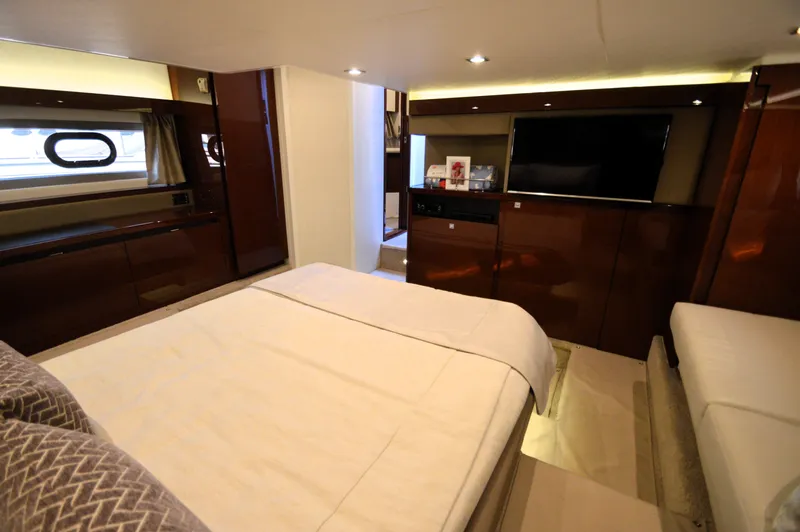 Slide: The Image of Luxurious cabin with double bed, wood furnishings, and flat-screen TV on a Sea Ray 460 Express Cruiser. - 41