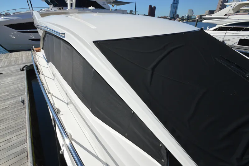 Slide: The Image of A 2018 Sea Ray 460 Express Cruiser docked. The windows are covered with black shades. - 15