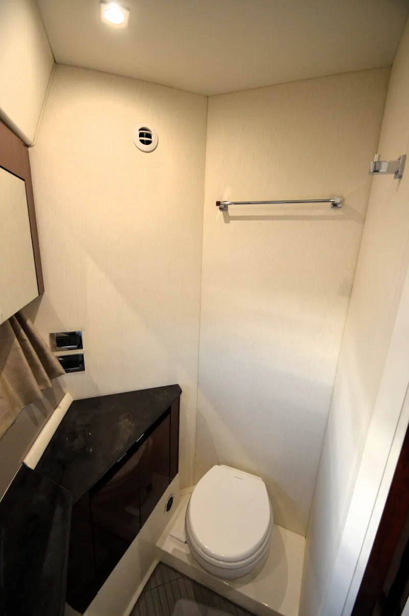 Slide: The Image of The image shows a modern boat bathroom with a toilet, sink, and towel rack. - 44