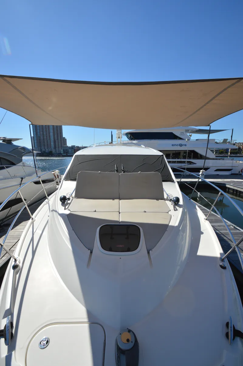Slide: The Image of The 2018 Sea Ray 460 Express Cruiser is docked, featuring a sunshade and sleek design. - 13