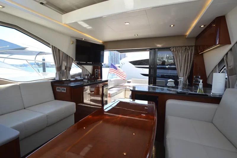 Slide: The Image of Interior of a luxury yacht with white sofas and wooden table, overlooking the water. - 24