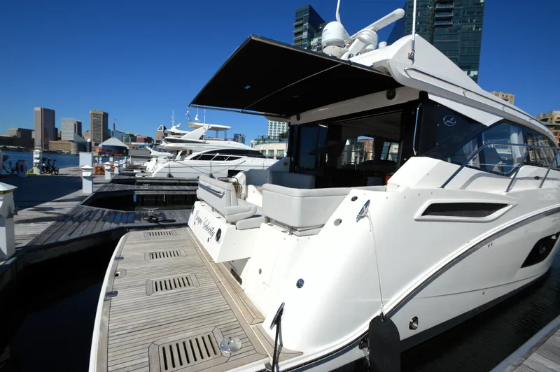 Slide: The Image of A luxurious 2018 Sea Ray 460 Express Cruiser docked at a modern marina. - 16